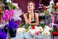 young woman flower store manager standing at workplace and smiling reopening shop sale 8 March Royalty Free Stock Photo