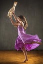 Young woman in purple dress dancing with antique carousel horse. Royalty Free Stock Photo