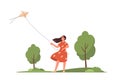 Young woman flying a kite in a green park. Royalty Free Stock Photo