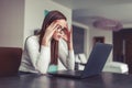 Young woman focusing on work at laptop in home office