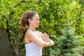 Young woman practices yoga in the summer garden - Namaskar Mudra