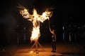 Young woman, the follower of Ukrainian pagan cult, torching the paper scarecrow on the sandy beach of the river