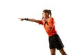 Young woman, football referee in uniform pointing and blowing whistle, controlling game rules against white studio Royalty Free Stock Photo