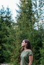 Young woman in forest. Portrait of a young caucasian girl in profile against background of trees, fir trees and forest Royalty Free Stock Photo