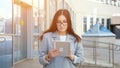 young woman in a formal suit and glasses looks into a tablet on the street Royalty Free Stock Photo