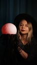 A young woman fortune teller in a hat is holding a magic ball. Royalty Free Stock Photo