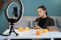 Young woman fortune teller recording video for blog using tarot cards, smartphone and ring lamp, predicts future online Royalty Free Stock Photo