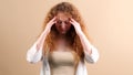 Young woman fottball fan with red hair touching her temples with hands, she can not beleive her team lost the game.