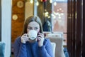 Young woman freelancer enjoying coffee during cellular conversation in cafe interior Royalty Free Stock Photo