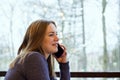 Young woman freelancer enjoying coffee during cellular conversation in cafe interior Royalty Free Stock Photo