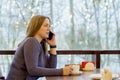 Young woman freelancer enjoying coffee during cellular conversation in cafe interior Royalty Free Stock Photo