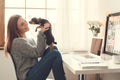 Young woman freelancer indoors home office concept winter atmosphere sitting with dog Royalty Free Stock Photo