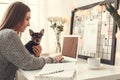 Young woman freelancer indoors home office concept winter atmosphere sitting with pet working Royalty Free Stock Photo