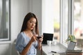 Young woman freelancer l take a break and drinking coffee in office. Royalty Free Stock Photo