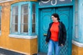 Young woman in front of an old house with a yellow facade and a decorated blue door in a small town in Denmark Royalty Free Stock Photo