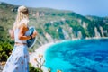 Young woman in front of Petani beach Kefalonia admiring highly excited picturesque panorama of emerald bay of