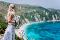 Young woman in front of Petani beach Kefalonia admiring highly excited picturesque panorama of emerald bay of