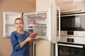 Young woman with frozen cherries near open refrigerator Royalty Free Stock Photo