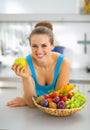 Young woman with fruits plate eating apple