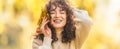 Young woman full of emotions from autumn season. Girl with a dental braces and curly hair