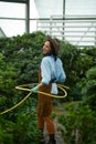 Young woman gardener having fun with watering hose Royalty Free Stock Photo