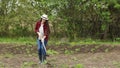 Young woman gardener with hoe