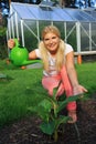 Young woman gardener watering plant