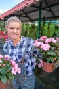 Happy  woman gardener choosing flower pot with anthuriums in garden center Royalty Free Stock Photo