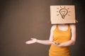 Young woman gesturing with a cardboard box on her head with light bulb Royalty Free Stock Photo