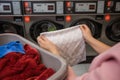 Young woman get dirty clothes to the washing machine in the laundry room Royalty Free Stock Photo
