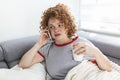 Young woman getting bad news by phone. unhappy woman talking on mobile phone looking down. Crying depressed girl holds phone Royalty Free Stock Photo