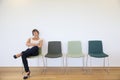 Young woman getting bored sitting in waiting room Royalty Free Stock Photo