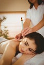 Young woman getting ear candling treatment