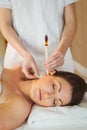 Young woman getting an ear candling treatment Royalty Free Stock Photo