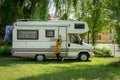 Young woman getting into her motorhome parked on grass Royalty Free Stock Photo