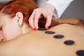 Young woman getting hot stone massage in spa salon. Royalty Free Stock Photo
