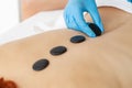 Young woman getting hot stone massage in spa salon. Royalty Free Stock Photo