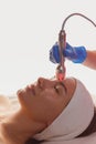 Young woman getting microcurrents skin cleansing and face treatment at beauty salon