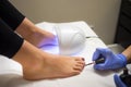 young woman getting a pedicure applying semi-permanent nail polish