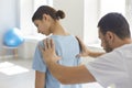 Young woman getting procedure of fixing joints and acupuncture from chiropractor