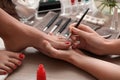 Young woman getting professional pedicure in beauty salon, closeup