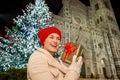 Young woman with gift box near Christmas tree in Florence, Italy Royalty Free Stock Photo