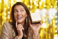 Young woman with gift over gold background Royalty Free Stock Photo