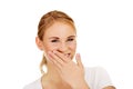 Young woman giggles covering her mouth with hand