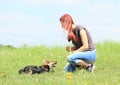 Young woman playing with black and brown furry dog