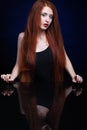 Young woman with ginger hair over reflection mirror on blue back Royalty Free Stock Photo