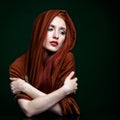 Young woman with ginger hair and scarf on green background Royalty Free Stock Photo