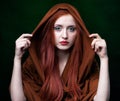 Young woman with ginger hair and scarf on green background Royalty Free Stock Photo