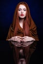 Young woman with ginger hair and scarf over reflection mirror on Royalty Free Stock Photo