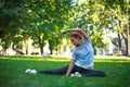 Young woman in city park on green grass doing stretching fitness exercises outdoors Royalty Free Stock Photo